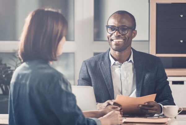 Employment Practice Liability Insurance - Portrait of Smiling Optimistic Manager Looking at His Female Colleague While Sitting at Table and Having a Pleasant Discussion