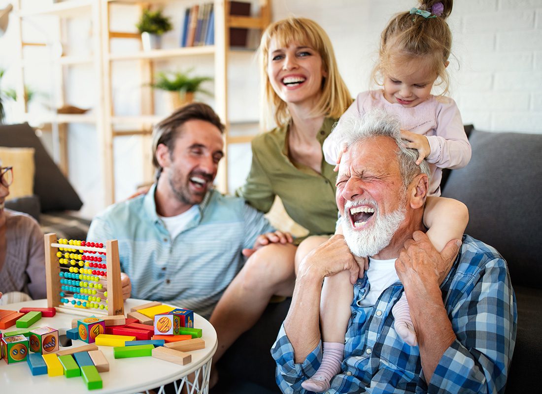 About Our Agency - Grandfather and Family Have Fun Together at Home and Laughing